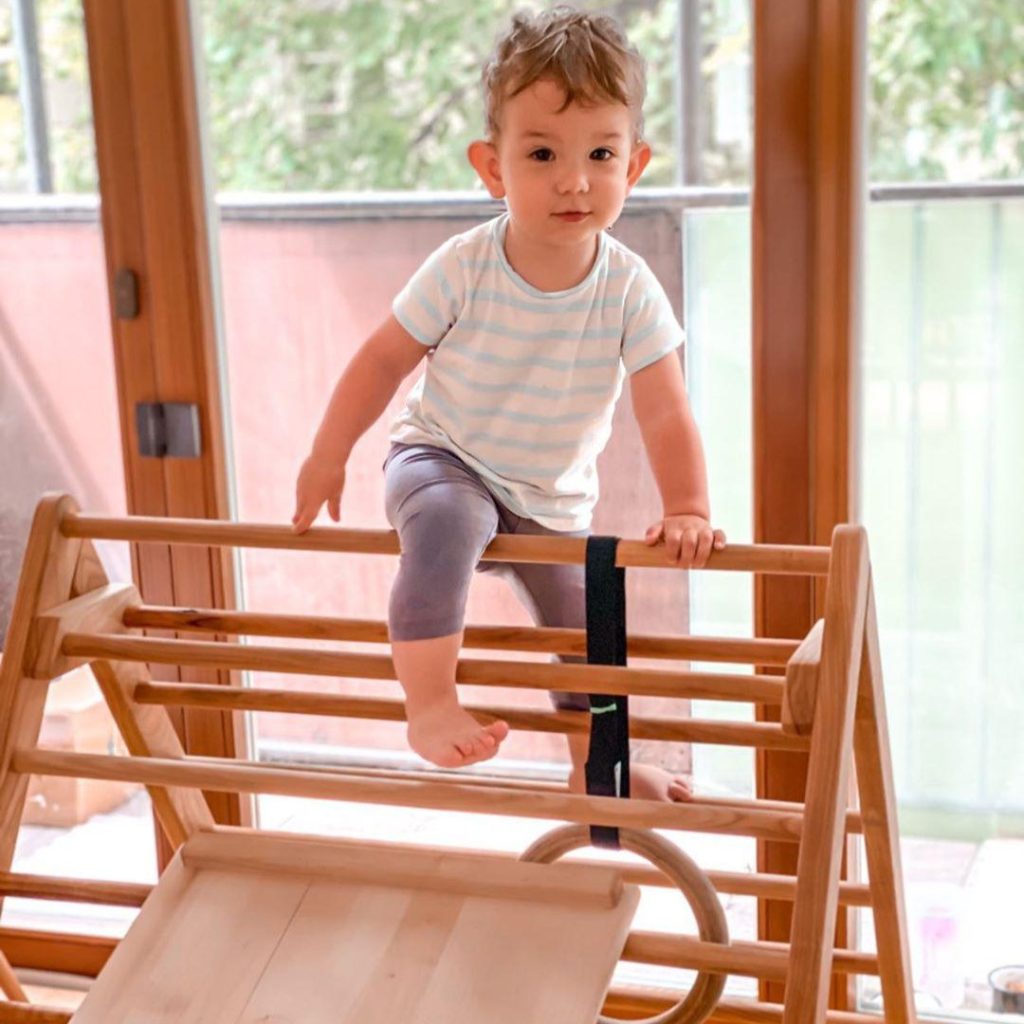 toddler climbing on pikler triangle